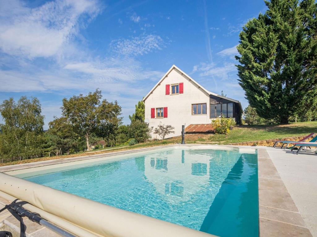 a swimming pool in front of a house at Cozy holiday home in Thédirac in Thédirac