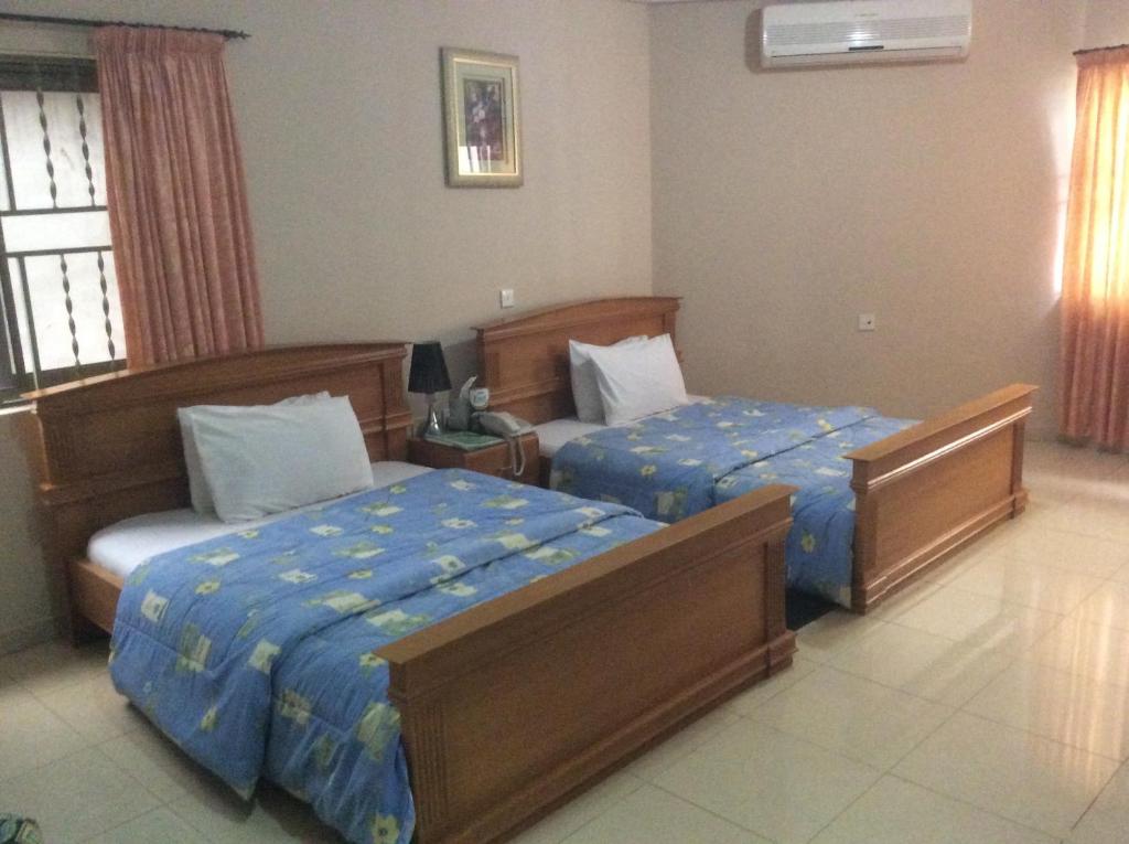 a hotel room with two beds in a room at Eastgate Hotel in Accra