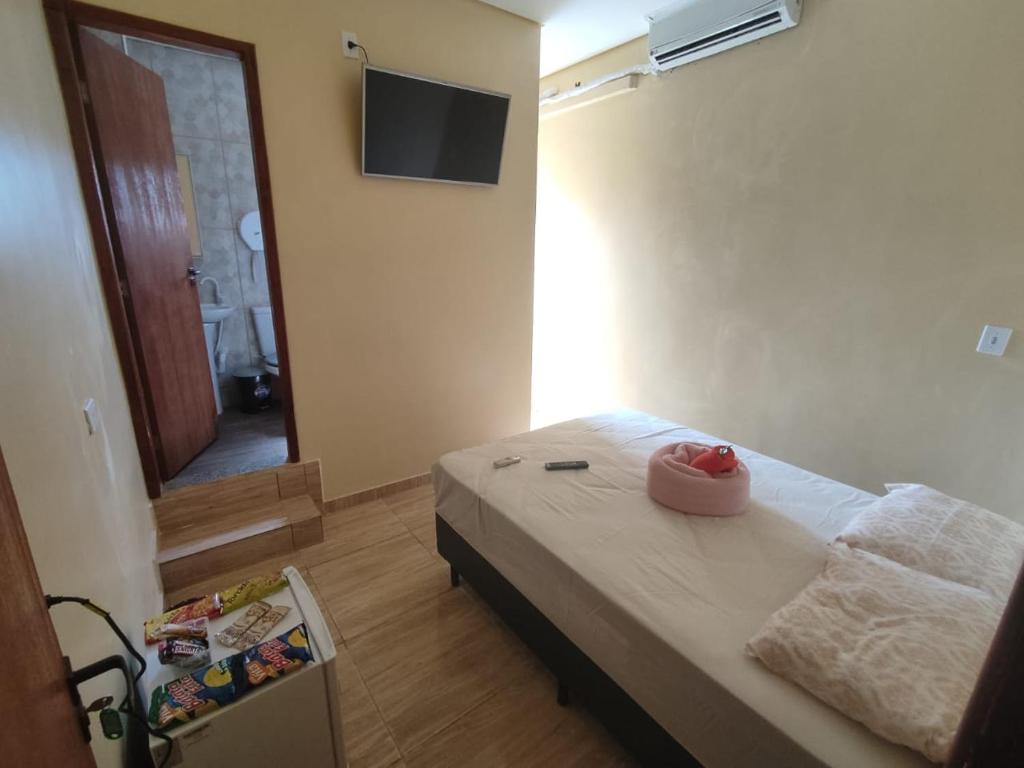 a bedroom with a bed and a dresser at Hostel Aeroporto in Guarulhos