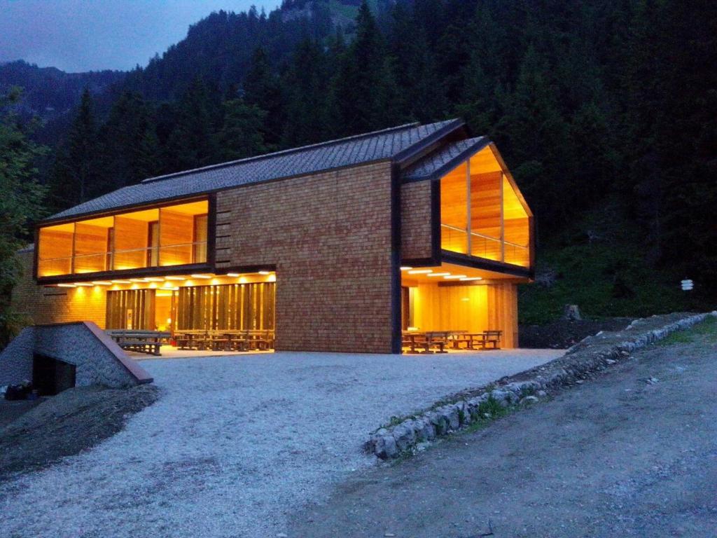 a brick house with large windows on a hill at Vallesinella Hotel Restaurant Bar in Madonna di Campiglio