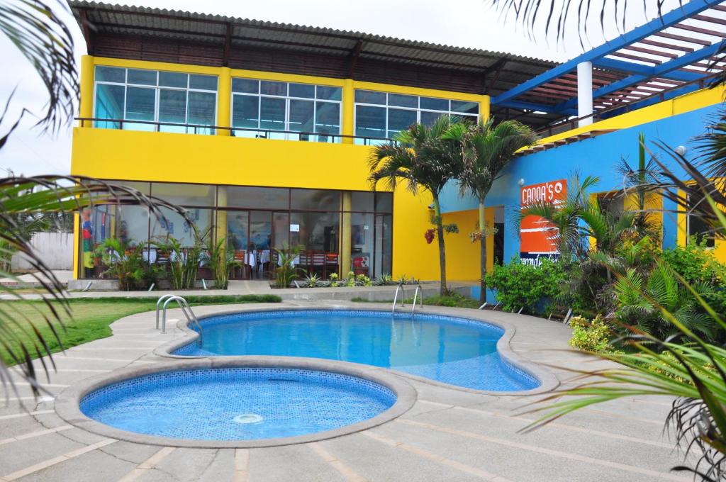 a swimming pool in front of a building at Hotel Canoa´s Wonderland in Canoa