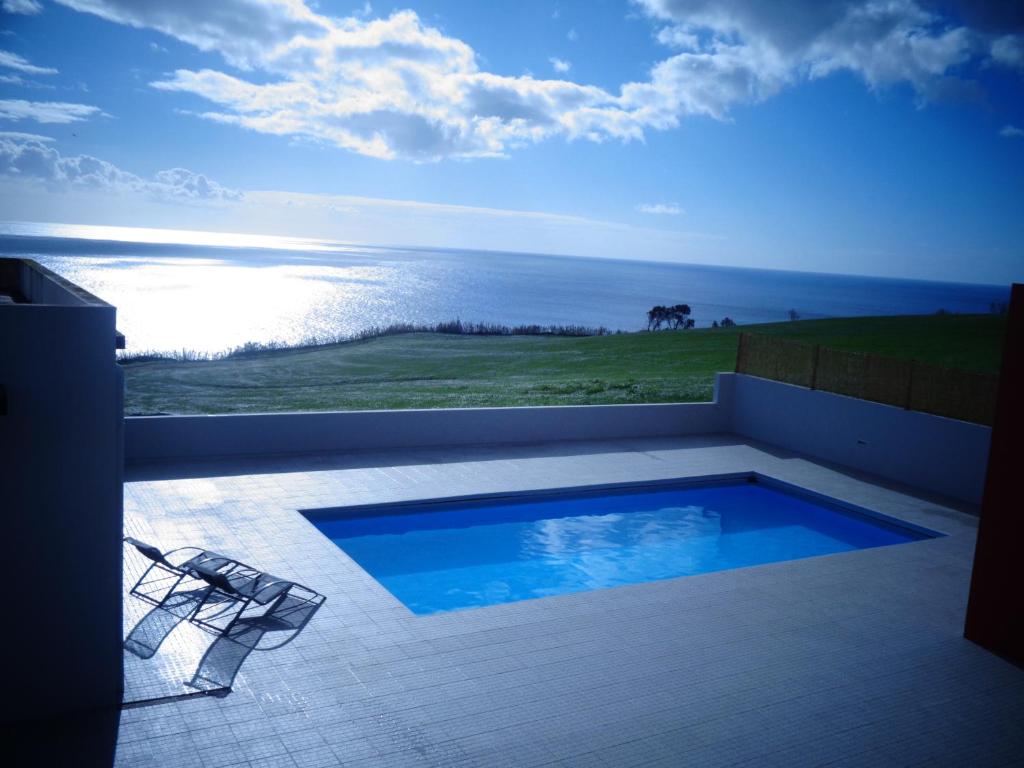 a swimming pool on a patio with a view of the ocean at Mar & Serra in Feteiras