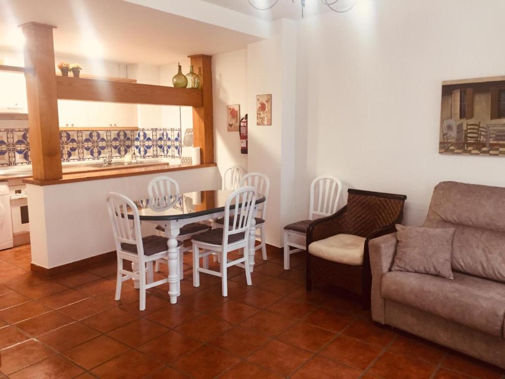 sala de estar con mesa, sillas y sofá en Casa Vacacional Torredano II en Nalda
