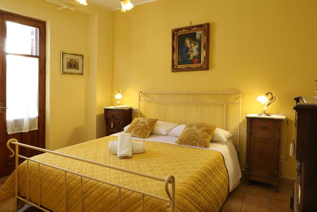 a bedroom with a large bed with yellow walls at Casa Antico Borgo Cuseni in Taormina