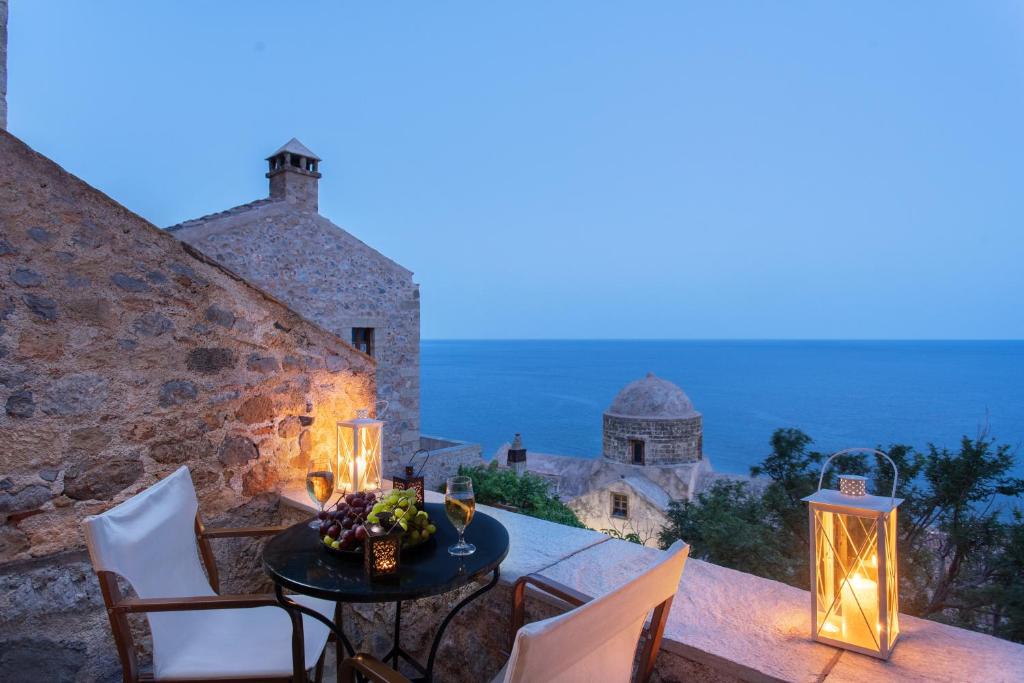 una mesa y sillas en un balcón con vistas en Pablito House, en Monemvasia