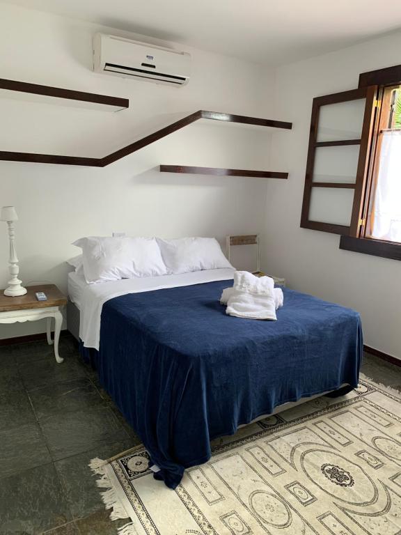 a bedroom with a bed with a blue blanket at Almas gêmeas quarto casal in Angra dos Reis