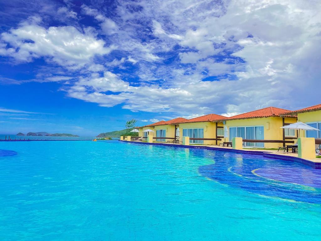 a swimming pool at a resort with blue water at Búzios Beach Resort in Búzios