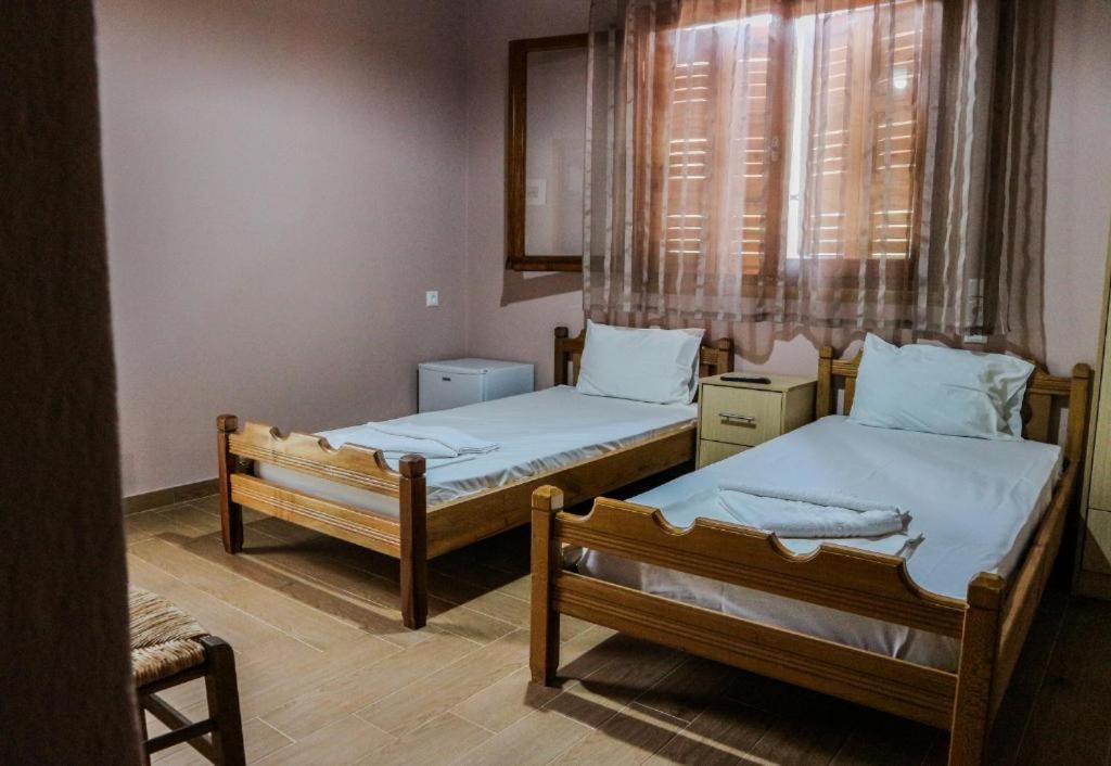 dwa łóżka w pokoju z oknem w obiekcie Hotel Elatofilito w mieście Athamanio