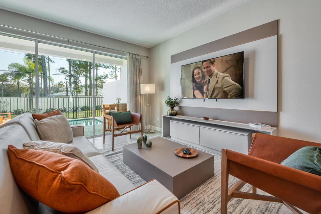 a living room with a couch and a tv at Formosa Valley by UNE Homes in Orlando