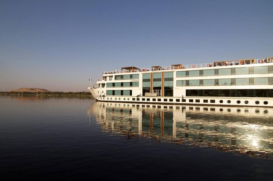 een cruiseschip is aangemeerd in het water bij Le Fayan Nile Cruise - Every Thursday from Luxor for 07 & 04 Nights - Every Monday From Aswan for 03 Nights in Luxor