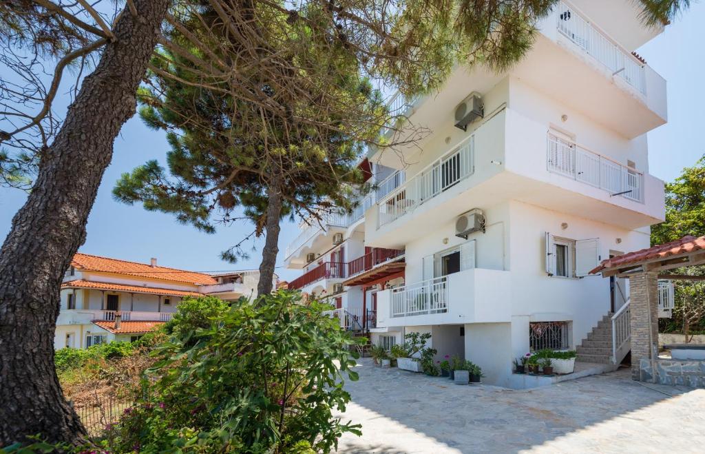 an apartment building with trees in the foreground at Tassos & Marios Apartments II in Alikanas