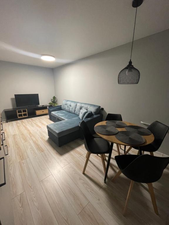 ein Wohnzimmer mit einem Sofa und einem Tisch in der Unterkunft Livinga 1 kambario butas centre in Mažeikiai