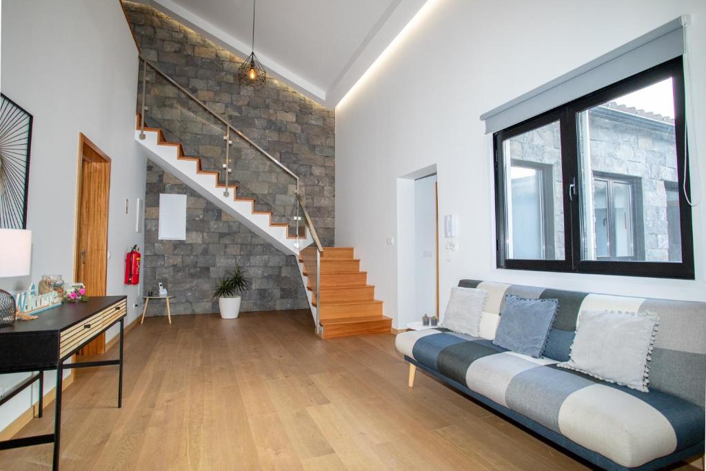 a living room with a couch and a staircase at Carvão PDL Inn in Ponta Delgada