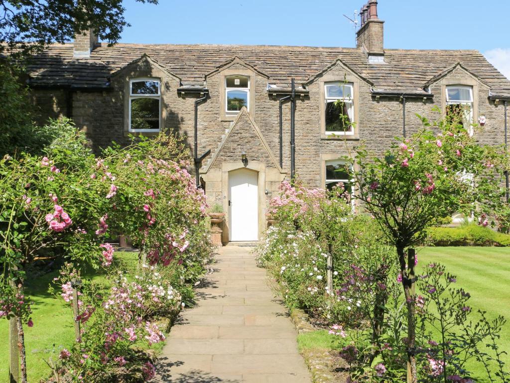 a brick house with a white door and some flowers at Manor House in Accrington