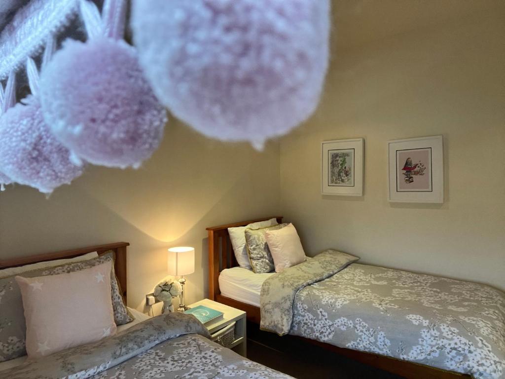 a bedroom with two beds and a ceiling with stuffed animals at The Lough Erne House at Golf Village Lough Erne Resort in Enniskillen
