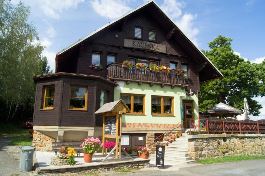 a house with a balcony and flowers on it at Hotel Kačenka in Králíky