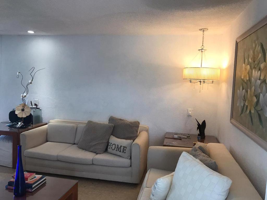 a living room with a couch and a table at La Palapa Acapulco in Acapulco