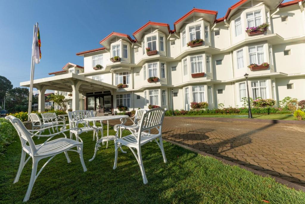 a table and chairs in front of a building at Galway Heights Hotel in Nuwara Eliya
