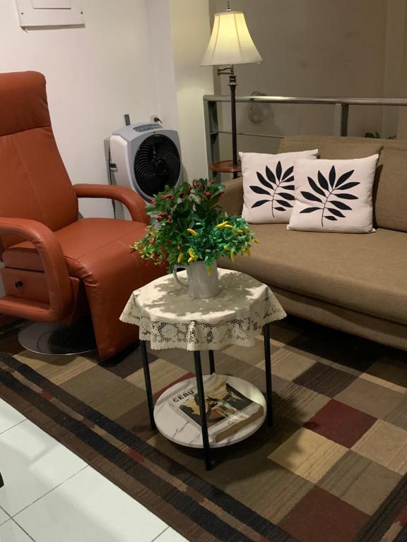 un soggiorno con divano e tavolo con piante di Will Come Home a Cebu City