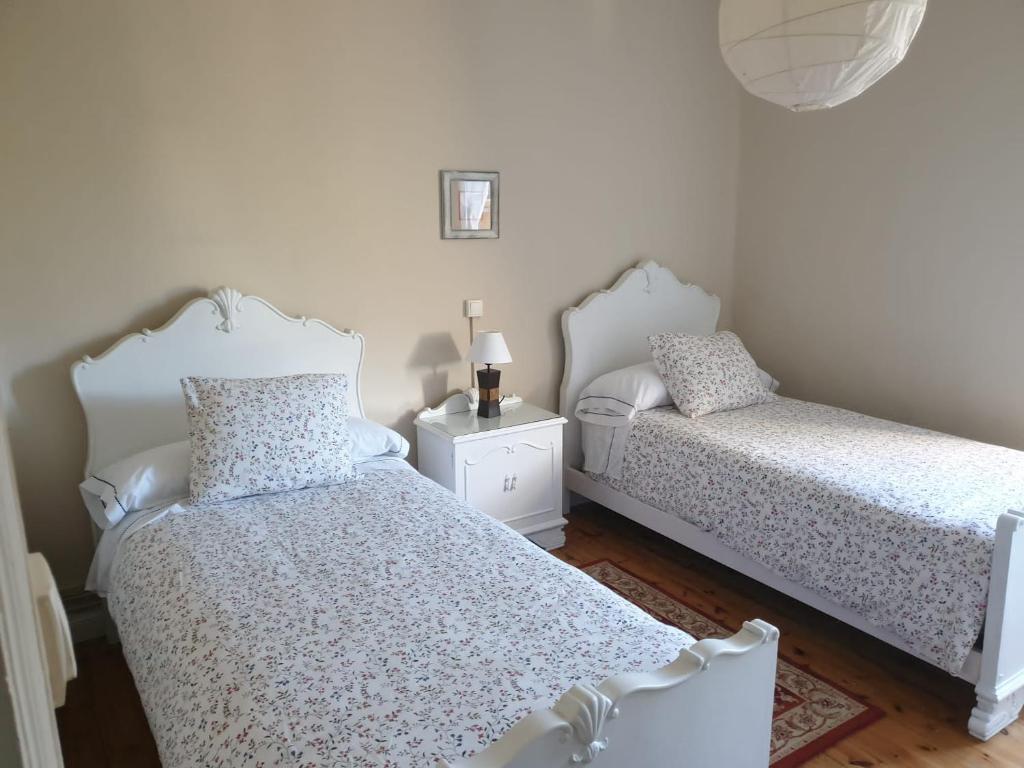 1 dormitorio con 2 camas y mesa con lámpara en La casa de los abuelos, en Zurita