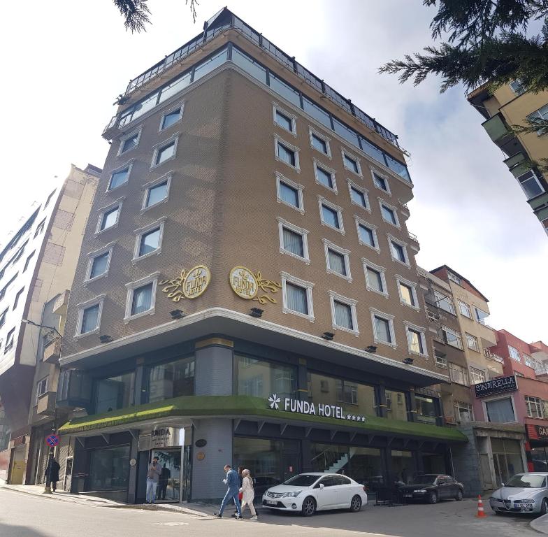 un edificio con un reloj en la parte delantera en Funda Hotel, en Trabzon