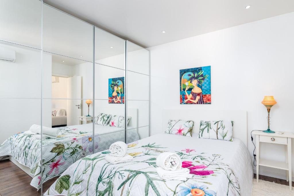 Un dormitorio blanco con una gran pared de cristal en Tilias Apartment at Estoril, en Estoril