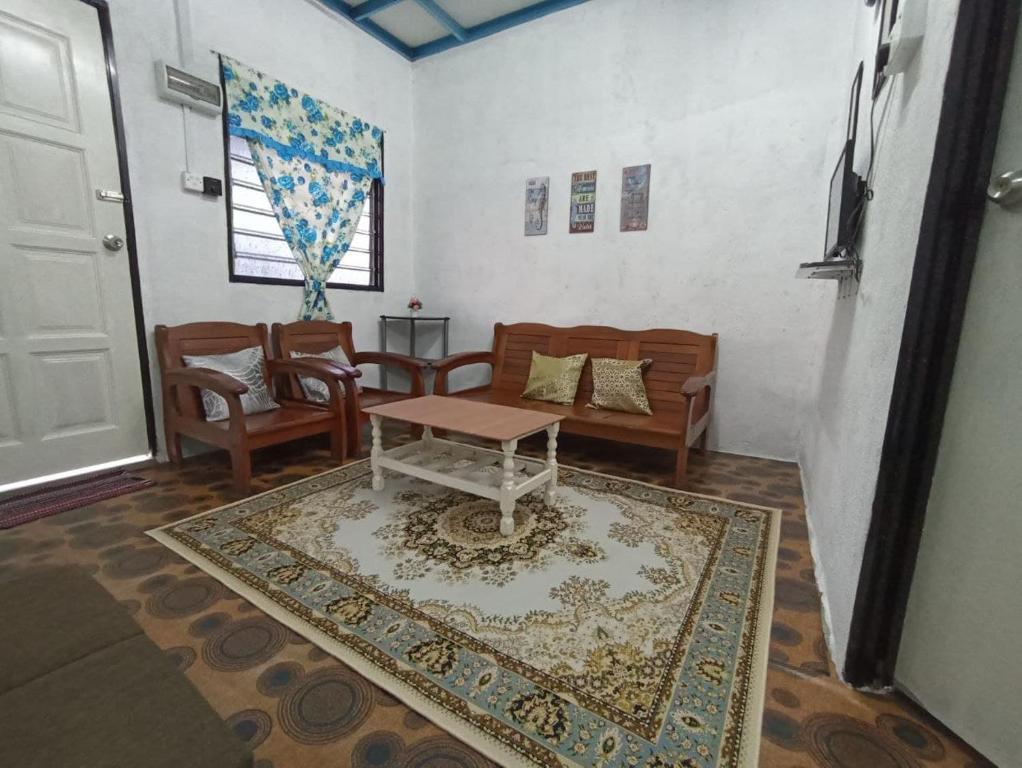 a living room with a table and a couch and a rug at HOME2STAY CHE MAIL 1 KUALA ROMPIN in Kuala Rompin