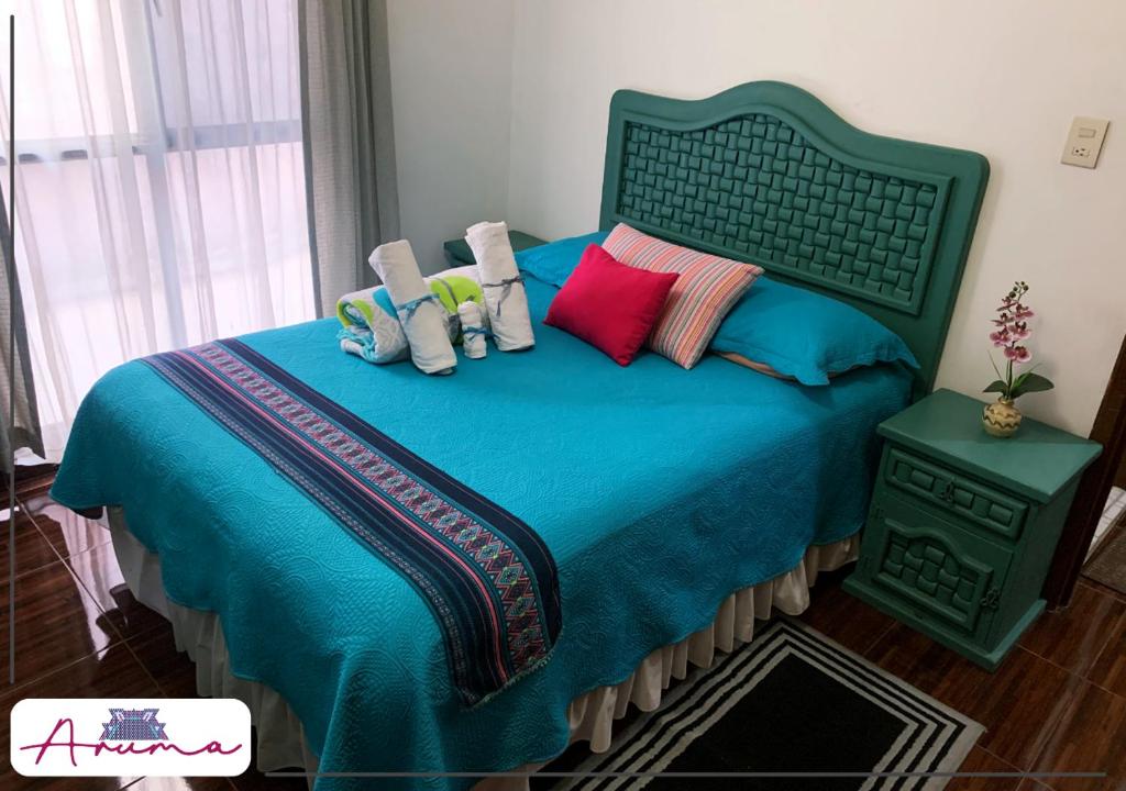 una camera da letto con letto blu e cuscini colorati di Aruma Cuernavaca a Cuernavaca