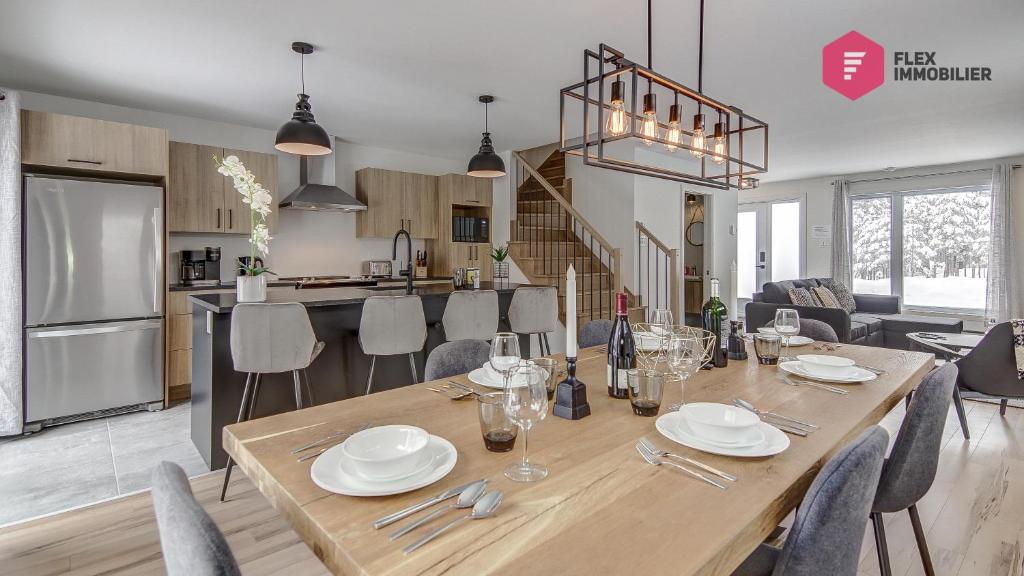 a dining room and kitchen with a table and chairs at La Fleur Urbaine de Portneuf : 2.5 bathrooms, Hot tub, Sauna and Pool in Pont-Rouge