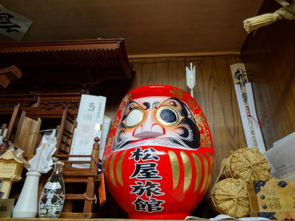 a large red vase sitting on top of a table at Jizokan Matsuya Ryokan in Nagano