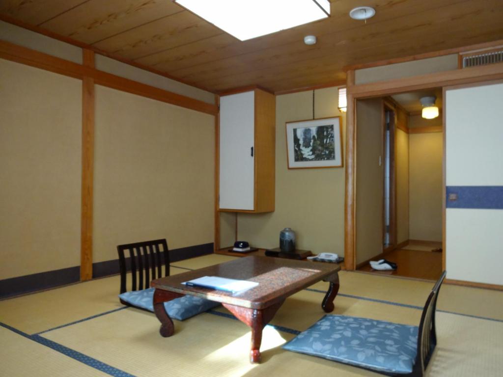 a living room with a table and a chair at Jizokan Matsuya Ryokan in Nagano