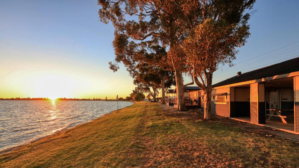 a building next to a body of water at Lake Boga Caravan Park in Lake Boga