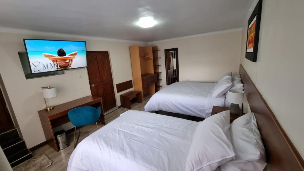 Una habitación de hotel con dos camas y un televisor de pantalla plana. en Departamento INCA PALACE EXPERIENCE, en Puno