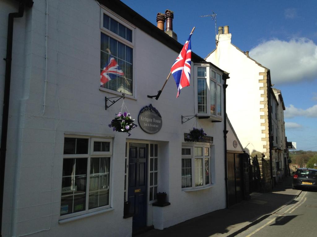 deux drapeaux cassis battant à l’extérieur d’un bâtiment blanc dans l'établissement Kirkgate House, à Knaresborough