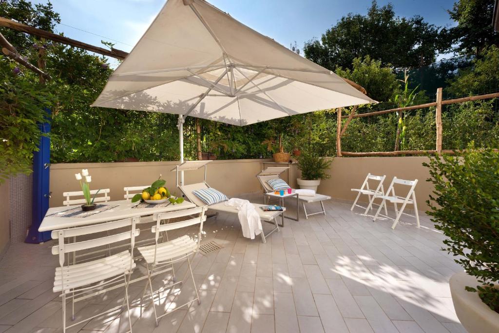 un patio con mesa, sillas y sombrilla en Sorrento Central Flat en Sorrento