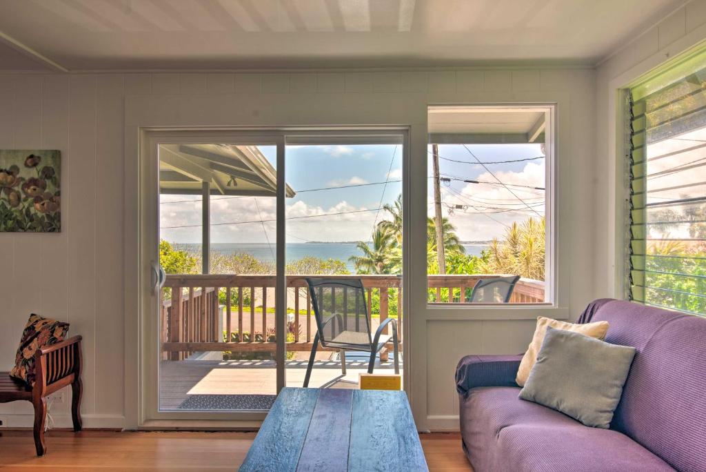 uma sala de estar com um sofá roxo e uma varanda em Hilo Apartment Ocean Views on the Hamakua Coast! em Hilo