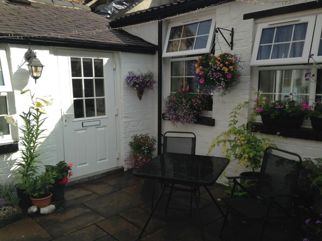 a house with a white door and some plants at Courtyard Cottage in Knaresborough