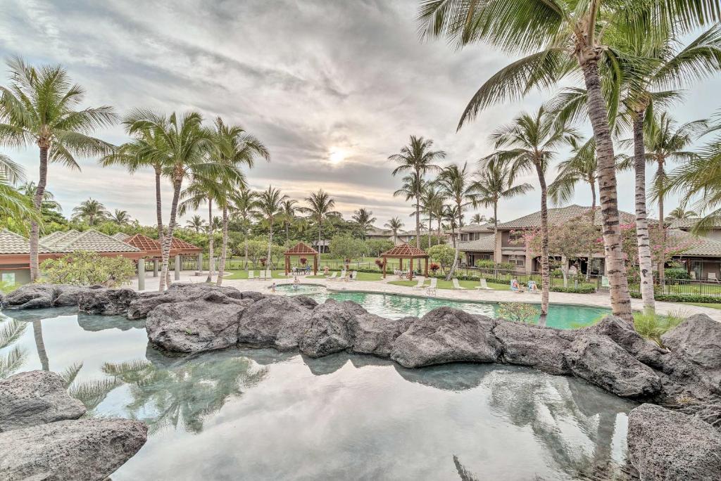 a swimming pool with palm trees in a resort at Luxe Big Island Vacation Rental Along Kohala Coast in Waikoloa