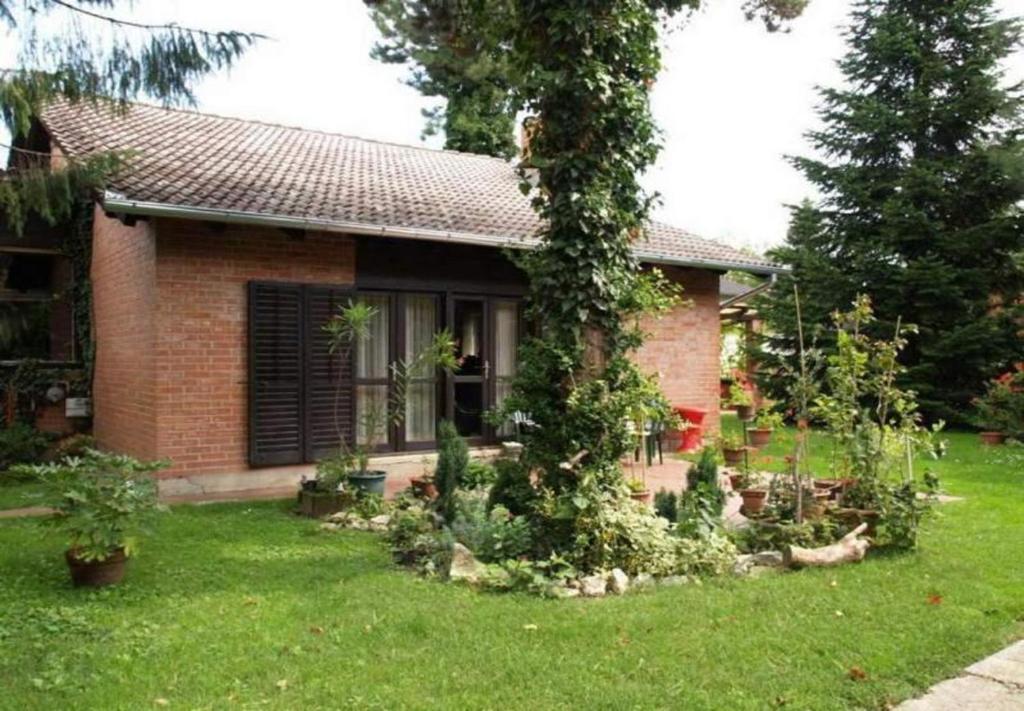 una pequeña casa de ladrillo con jardín en el patio en Rooms Branka - colorful, en Križevci