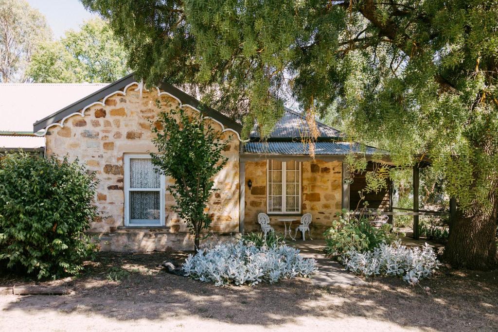 a stone house with a tree in front of it at Mintaro Hideaway in Mintaro