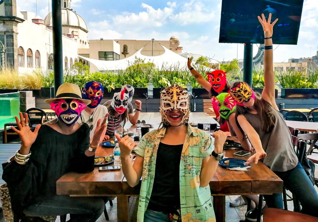 a group of people wearing masks at a table at Casa Pepe Hostel Boutique - CDMX in Mexico City