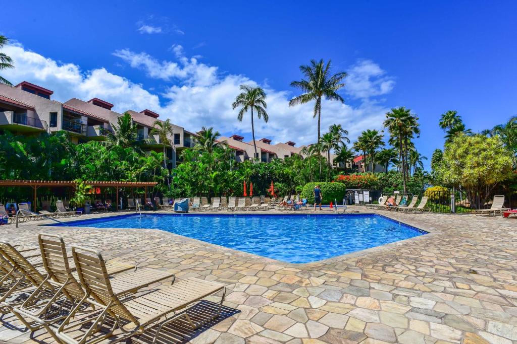 a swimming pool with chairs and palm trees at Ocean View Kihei Retreat with Resort Amenities! in Wailea
