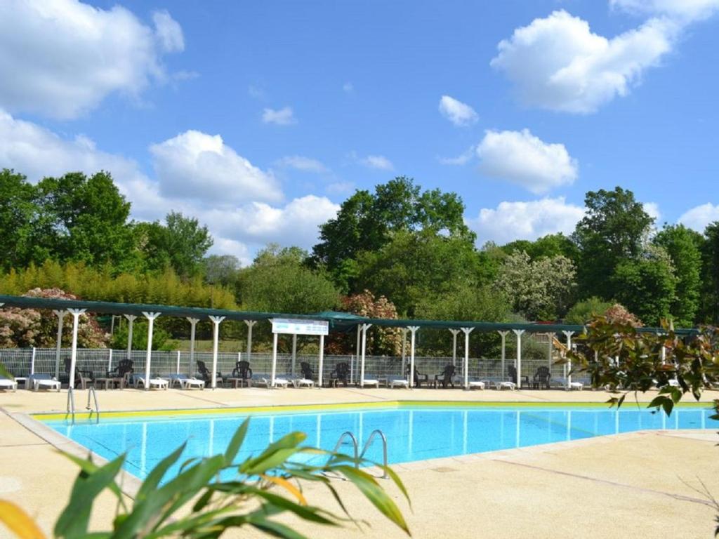 a swimming pool in a park with trees in the background at Mobil Home Saint Paul lès Dax in Saint-Paul-lès-Dax