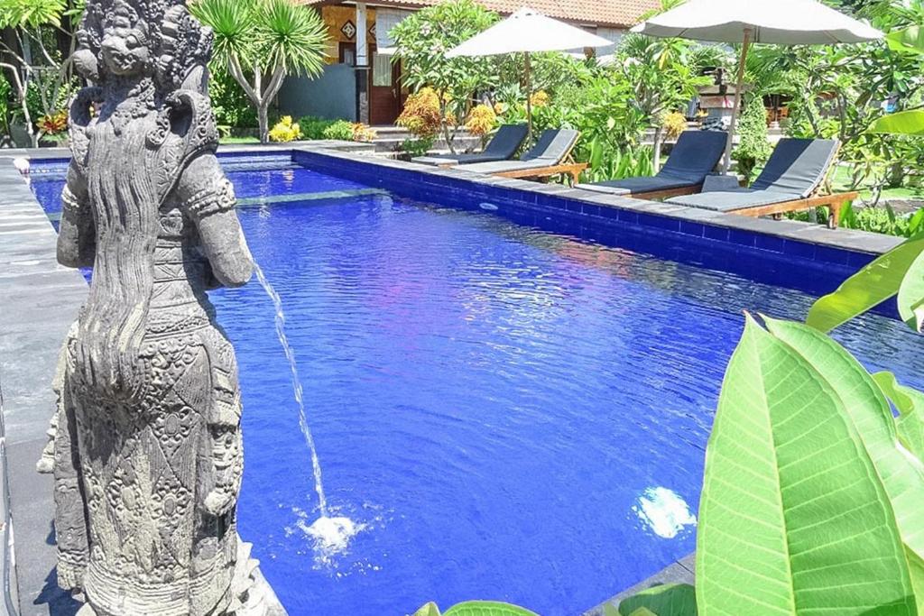 a fountain in the middle of a swimming pool at Perdana Homestay Lembongan in Nusa Lembongan