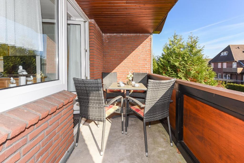 eine Terrasse mit einem Tisch und Stühlen auf dem Balkon in der Unterkunft Ferienwohnungen im Haus am Wattenmeer in Neuharlingersiel