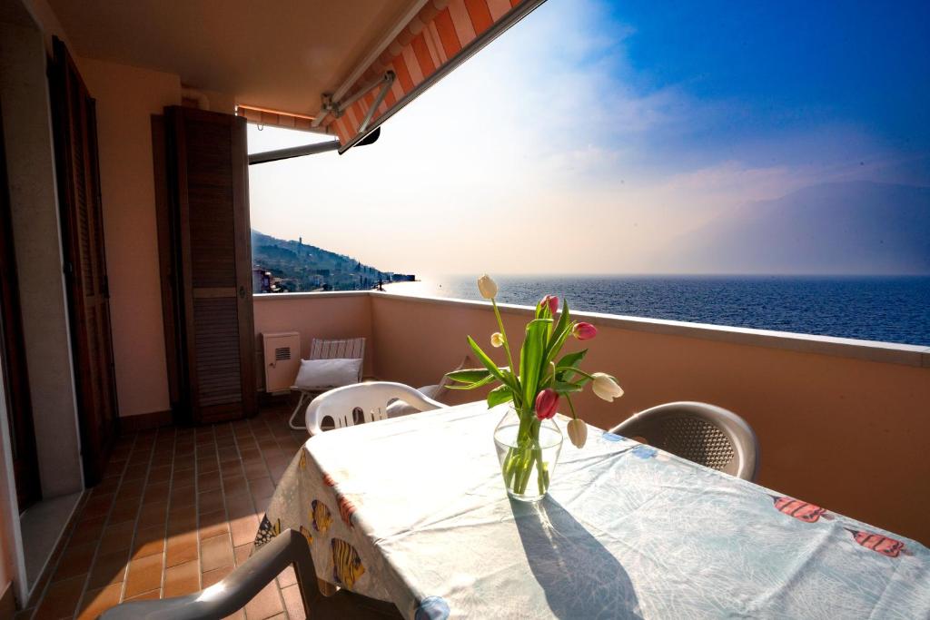 a vase of flowers sitting on a table with the ocean at Le Vele Beth's House in Brenzone sul Garda