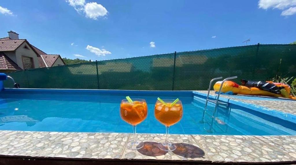 two cocktails sitting on a table next to a swimming pool at Apartmán Ivona in Štípa