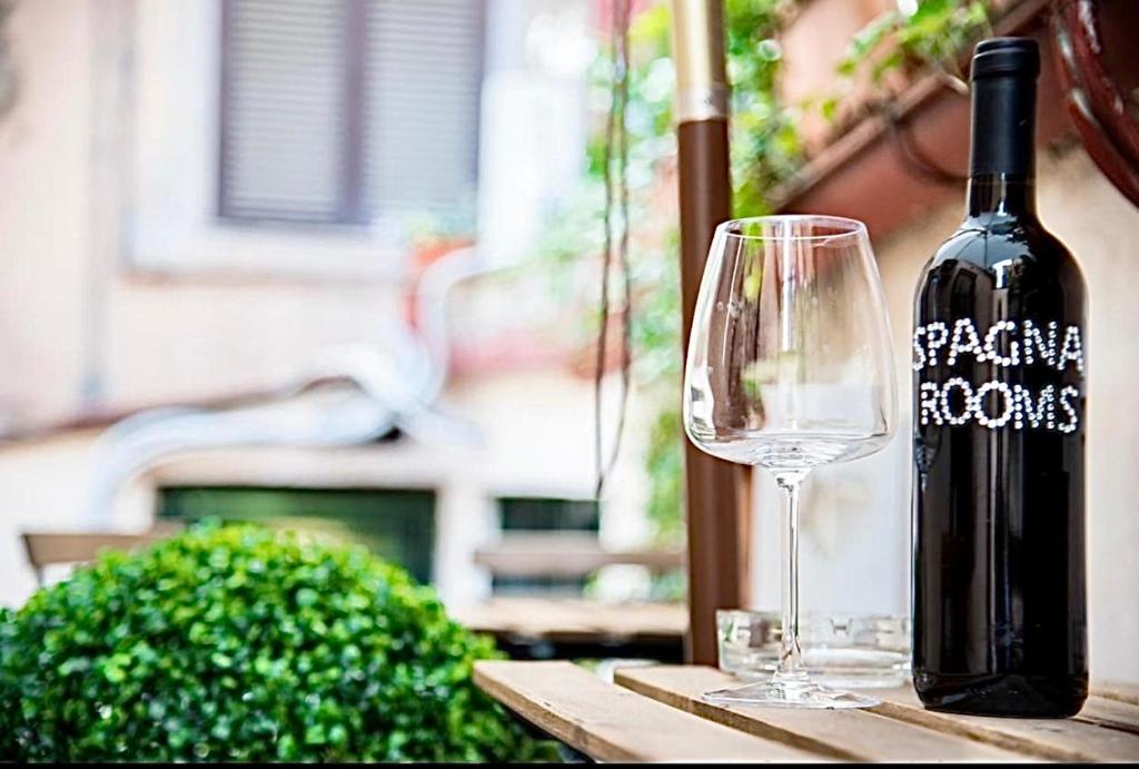 una bottiglia di vino e un bicchiere su un tavolo di Spagna Rooms a Roma