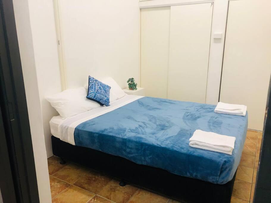 a bedroom with a blue bed with towels on it at Entire 4 Bedroom pets friendly home in Alice Springs CBD with 2 kitchens 2 bathrooms Toilets and plenty of free secured parking in Alice Springs