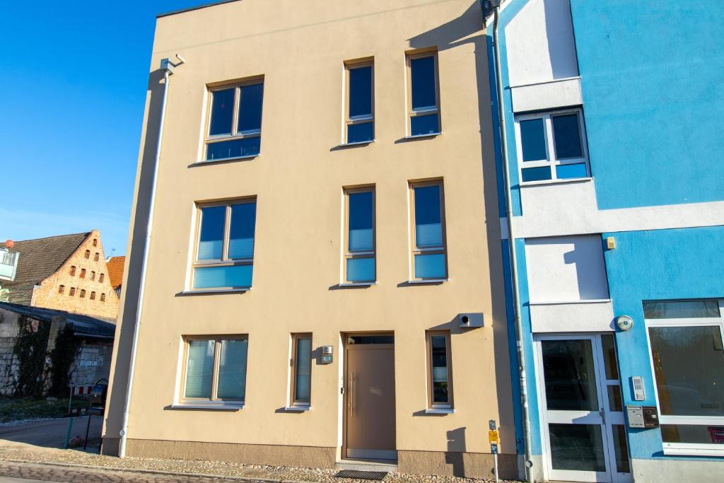ein Apartmenthaus vor einem blauen Gebäude in der Unterkunft Altstadt Ferienwohnung Pipo in Stralsund